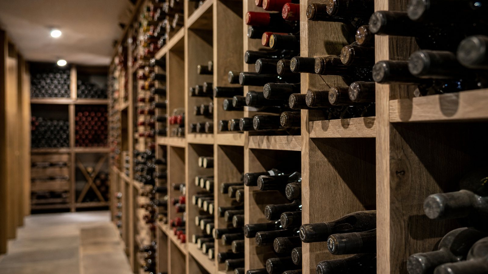 Bouteilles classées par région et par millésime dans les casiers en bois d'une cave organisée